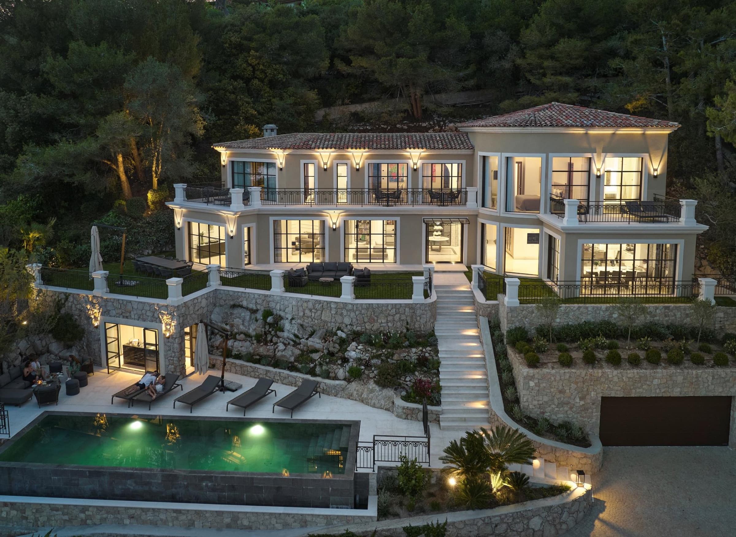 Villa Aurore lit at dusk, pool and terraced gardens